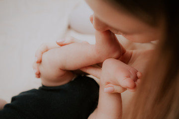 Obraz na płótnie Canvas mother kisses the feet of baby 