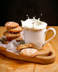 milk splashing out of a cup and cookies