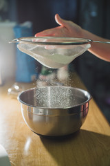 Sifting flour into a mixing bowl