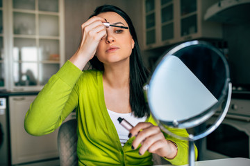 Attractive Caucasian woman blogger beautician creating new content for her blog on social networks. Woman making make-up for her beauty blog on cosmetics. Modern technology, internet, blogging.