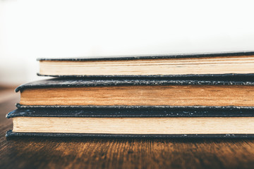 close-up shot of stack of vintage books on rustic wooden table