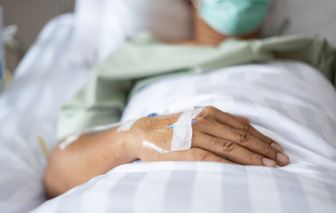 Obraz premium Needle On Patient covid 19 or coronavirus Hand lying in hospital room The Hospital