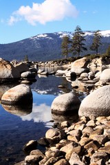 mirror reflection of the sierras in Lake Tahoe, USA by the rocky shore