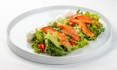 Salmon salad with cheese balls on a white plate