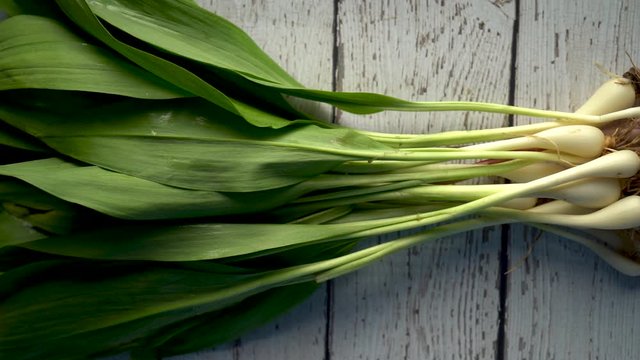 Flat lay of fresh ramps on a white distressed wood background backlit.