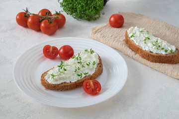 Sandwich on whole grain bread with homemade cream cheese or cottage cheese, microgreens and cherry tomatoes. Healthy food, balanced food concept. Horizontal orientation, selective focus.