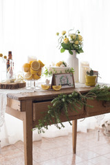 Wooden table decorated with lemon, flowers and cake