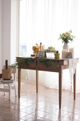 Wooden table decorated with lemon, flowers and cake