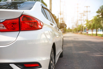 White cars parked on the roadside, with natural backgrounds and with bright sunlight.