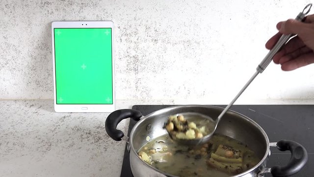 Serving laddle from chockpea stew and tablet