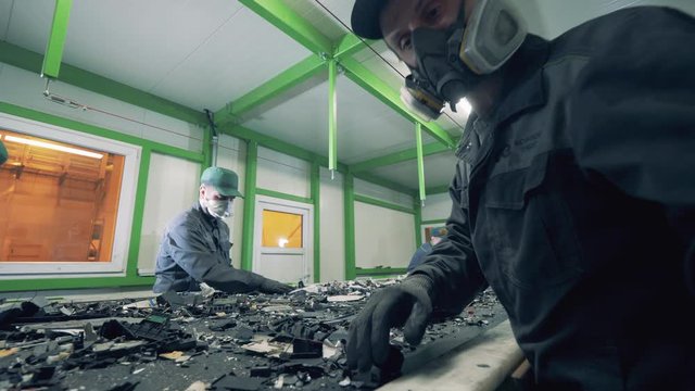 Junkyard employees are inspecting pieces of broken electronics