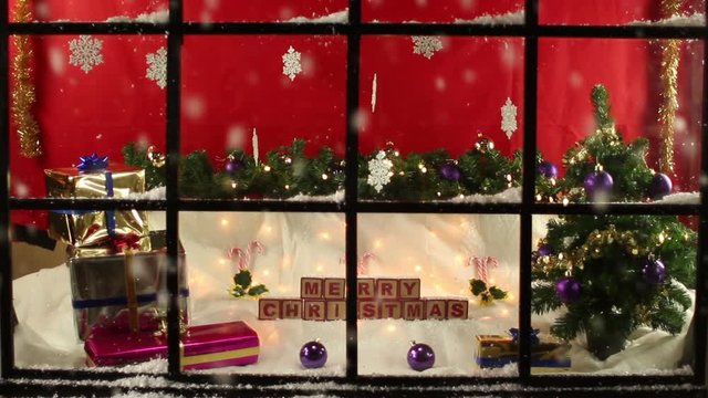 Shop window display front at Christmas with gifts the other side of the glass. Snowing outside. Looking in. Stock Video Clip Footage