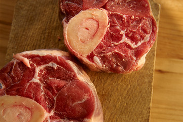 Horizontal photo with slices of beef bone with salt and other spices around for dinner at home. Bones are placed on desk.