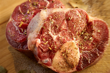 Horizontal photo with slices of beef bone with salt and other spices around for dinner at home. Bones are placed on desk.