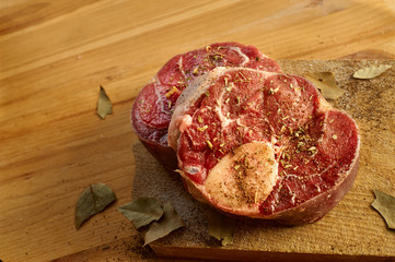 Horizontal photo with slices of beef bone with salt and other spices around for dinner at home. Bones are placed on desk.