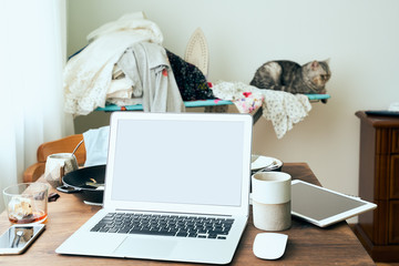 Freelance Desk with laptop in mess at home apartment. Quarantine, self-isolation, sociophobia