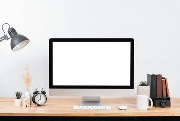 Mockup Blank screen desktop computer and decorations on wood table and white wall background.