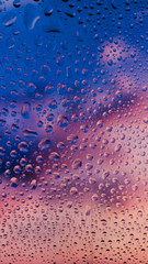 pattern di gocce d'acqua su vetro colorato di rosso e blu