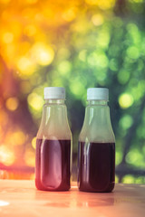 Tasty cold coffee in plastic bottle on wood table