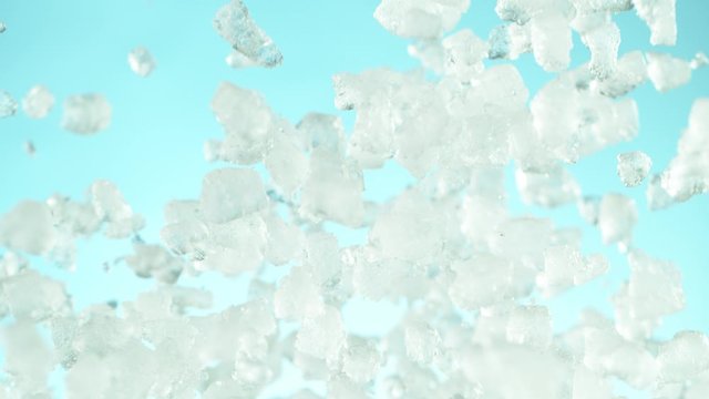 Super slow motion of falling crushed ice separated on blue background. Filmed on high speed cinema camera, 1000 fps.