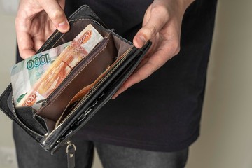 man with a black wallet full of russian money