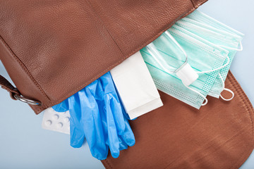 protective medical mask, sanitizer gel and gloves in bag. protective measures against virus, bacteria
