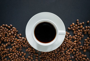 Cup of black coffee on black background with roasted coffee beans