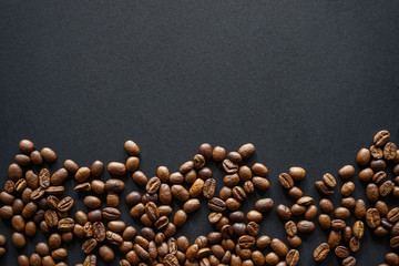 Roasted coffee beans on black paper background 