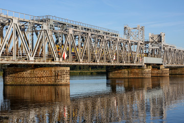 Train passing through an industrial railway bridge