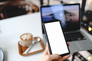 Mockup image of a woman holding and showing black mobile phone with blank screen in cafe.