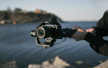 man holds camera with stabilization gimbal using his two hands