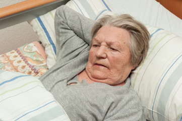 Alte Frau liegt im Bett