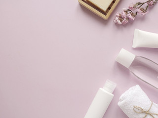 care products lotion, cream, plant, soap, towel. bath accessories on pink background, top view, copyspace. Bodycare beauty treatments at home concept, organic products, morning routine