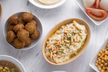 arab breakfast with hummus and falafel and fattah and foul on white wooden table Jordanian food 