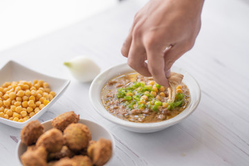 arab breakfast with hummus and falafel and fattah and foul on white wooden table Jordanian food 