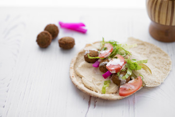 arab breakfast with hummus and falafel and fattah and foul on white wooden table Jordanian food 