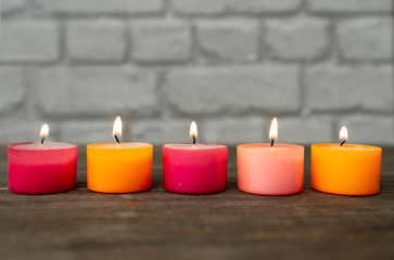 five red an orange tealight candles in a row
