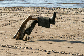 Fishing boots on a driftwood on a beach
