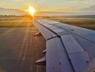 Fototapeta na wymiar View of plane wing while taking of or landing on airstip