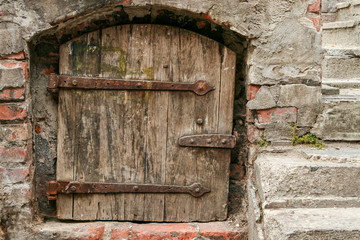 Old rustic Middle Ages timber door with rusty metal hinges