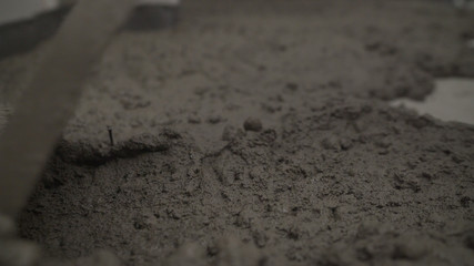 A professional worker is laying the floor. Laying concrete floor with mortar. Laying mortar on the floor.