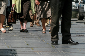 Fototapeta na wymiar People feet's walking on a dark pavement