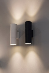Black and white lamps on the wall, lighting from lamps. Interior