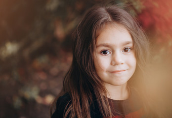 Fototapeta premium Portrait of cute little girl in autumn forest.