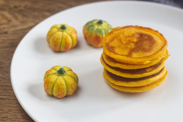 Homemade pumpkin pancakes on the white plate.