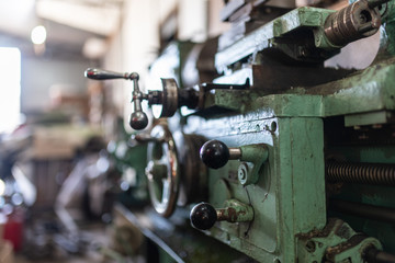 The old lathe machine is painted green.