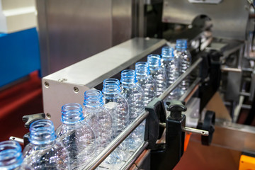 The PET bottles in the rail on the conveyor belt for filling process in the drinking water factory....