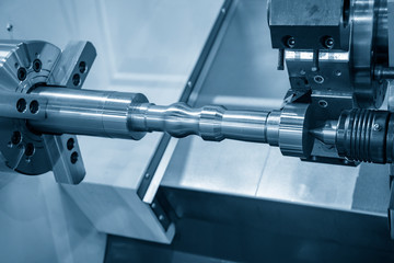 The CNC lathe machine rough cutting the metal shaft parts with cutting tools for make the automotive parts. The hi-technology metal working processing by CNC turning machine .
