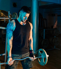 Homem jovem treinando hipertrofia muscular na academia de musculação 