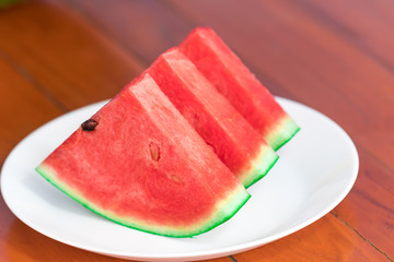 watermelon in dish white on wood flooring. close up
